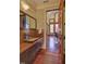 Stylish powder room featuring a glass vessel sink, wood countertop, and unique mirror at 805 Greenwood Rd, Chapel Hill, NC 27514