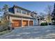 View of a spacious three-car garage featuring wooden doors, ample parking, and convenient access to the home at 805 Greenwood Rd, Chapel Hill, NC 27514
