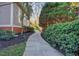 Stone walkway showcasing landscaped garden and mature trees that leads around the house at 805 Greenwood Rd, Chapel Hill, NC 27514