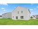 View of the home's back exterior featuring a well-maintained lawn and a sliding glass door entry at 857 Forth Ct, Gibsonville, NC 27249