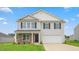 Charming two-story home featuring a two-car garage, stone accents, and a well-manicured lawn at 857 Forth Ct, Gibsonville, NC 27249