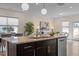 Granite island, stainless appliances, seating and pendant lights in spacious kitchen opening to living space at 917 Matterhorn Dr, Fuquay Varina, NC 27526