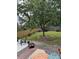 Landscaped backyard with a seating area, lush green lawn, wooden fence, and mature trees at 917 Widewaters Pkwy, Knightdale, NC 27545