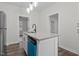 Kitchen island with sink, granite countertop, modern faucet and lighting adjacent to the stainless refrigerator at 1034 Maple St, Henderson, NC 27536