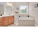 Bathroom boasts a large soaking tub with tile surround and light wood vanity at 1106 Bellenden Dr, Durham, NC 27713