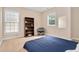 Neutral bedroom featuring a bookshelf and natural light from two windows at 1106 Bellenden Dr, Durham, NC 27713