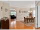Sunlit dining area featuring hardwood floors, a round table, and an open archway to the living room at 1106 Bellenden Dr, Durham, NC 27713