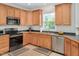 Kitchen area showcasing stainless steel appliances, wood cabinets, and neutral countertops at 1106 Bellenden Dr, Durham, NC 27713