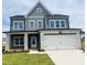 Two-story home boasts gray siding, stone accents, and a two-car garage, with a well-manicured lawn at 130 W Crescent Mills Blvd # Homesite 251, Wilson's Mills, NC 27520