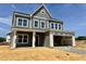 New two-story home shows gray siding, white trim, an open two-car garage, and covered front entry at 130 W Crescent Mills Blvd # Homesite 251, Wilson's Mills, NC 27520