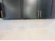 Close-up of the kitchen's elegant herringbone backsplash and sleek dark cabinetry with modern gold hardware at 130 W Crescent Mills Blvd # Homesite 251, Wilson's Mills, NC 27520