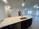 Spacious kitchen island with white countertop, dark cabinetry, and stylish pendant lighting above at 130 W Crescent Mills Blvd # Homesite 251, Wilson's Mills, NC 27520