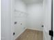 Functional laundry room with wood-look floors, a wire shelf for storage, and hookups for a washer and dryer at 130 W Crescent Mills Blvd # Homesite 251, Wilson's Mills, NC 27520