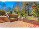 Brick patio with steps leading to the backyard, surrounded by lush greenery and trees at 1405 N Sellars Mill Rd, Burlington, NC 27217