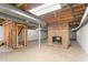 Unfinished basement features an exposed ceiling and a brick fireplace, perfect for future renovations at 1405 N Sellars Mill Rd, Burlington, NC 27217