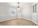 Well-lit dining room offering built-in corner cabinets, a modern light fixture, and wood-look flooring at 1405 N Sellars Mill Rd, Burlington, NC 27217