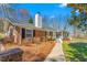 Charming brick home featuring a walkway, chimney, manicured landscaping, and an inviting front porch at 1405 N Sellars Mill Rd, Burlington, NC 27217