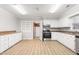 Spacious kitchen featuring white cabinets, stainless steel appliances, and efficient layout at 1405 N Sellars Mill Rd, Burlington, NC 27217