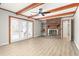 Spacious living room features a brick fireplace, wood beams, wood-look flooring, and a ceiling fan at 1405 N Sellars Mill Rd, Burlington, NC 27217