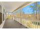 Inviting covered porch with white railings, providing a relaxing outdoor space with views of the surrounding greenery at 1405 N Sellars Mill Rd, Burlington, NC 27217