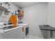 Functional laundry room with modern washer and dryer, overhead shelving, and folding table, providing convenience and storage at 1725 Langlais Dr, Graham, NC 27253