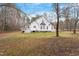 Extensive backyard showing mature trees, a deck, concrete patio, and lush green space at 173 Allie Dr, Garner, NC 27529