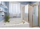 Bright bathroom features a jacuzzi tub and a shower with glass doors at 173 Allie Dr, Garner, NC 27529