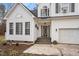 Charming front exterior with decorative door, arched windows, attached garage, and tasteful landscaping at 173 Allie Dr, Garner, NC 27529