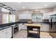 Bright kitchen features white cabinets, black countertops, an island, and stainless steel appliances at 173 Allie Dr, Garner, NC 27529