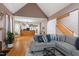 Open concept living space featuring a modern sofa, hardwood floors, and seamless transition to the kitchen at 173 Allie Dr, Garner, NC 27529