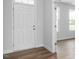 Bright entryway featuring a white front door, wood-look flooring, and contemporary trim at 173 Wild Turkey Way, Lillington, NC 27546