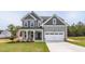 Charming two-story home with gray siding, white trim, covered porch, landscaped yard and two car garage at 173 Wild Turkey Way, Lillington, NC 27546