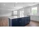 Bright kitchen with stainless appliances, white countertops, island with seating, and backyard access at 173 Wild Turkey Way, Lillington, NC 27546