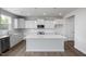 Bright kitchen features white cabinetry, stainless steel appliances, large island, and wood-look flooring at 173 Wild Turkey Way, Lillington, NC 27546