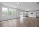 Expansive living space with natural light, wood floors, and open layout into the contemporary kitchen at 173 Wild Turkey Way, Lillington, NC 27546