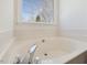Bright bathroom with a soaking tub next to a window at 1961 Indianwood Ct, Raleigh, NC 27604