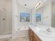Bathroom with double vanity, tub, shower, and a large window providing natural light at 1961 Indianwood Ct, Raleigh, NC 27604