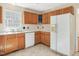 Kitchen featuring oak cabinets, a white refrigerator, and tile flooring at 1961 Indianwood Ct, Raleigh, NC 27604