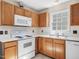 Kitchen featuring oak cabinets, laminate countertops, and white appliances at 1961 Indianwood Ct, Raleigh, NC 27604