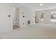 A large living room with carpet, a ceiling fan, and multiple windows at 1961 Indianwood Ct, Raleigh, NC 27604