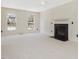 Living room with a black fireplace and mantle, two large windows, and neutral carpet at 1961 Indianwood Ct, Raleigh, NC 27604