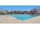 Large swimming pool with clear blue water, surrounded by a spacious deck and mature trees at 1961 Indianwood Ct, Raleigh, NC 27604