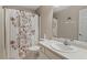 Clean bathroom featuring a toilet, sink, vanity, and floral-patterned shower curtain that adds a decorative touch at 201 Moss Creek Dr, Clayton, NC 27520