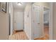 Hallway with multiple doors, wood flooring, and neutral paint, connecting different areas at 201 Moss Creek Dr, Clayton, NC 27520