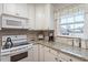 Well-lit kitchen featuring granite countertops, white cabinetry, and modern appliances at 201 Moss Creek Dr, Clayton, NC 27520