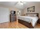 Spacious main bedroom featuring hardwood floors, wood dresser, and a large decorative wall painting at 201 Moss Creek Dr, Clayton, NC 27520