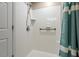 Bright shower with white tile, a shower head, and accessible grab bar features, showcasing practicality at 201 Moss Creek Dr, Clayton, NC 27520