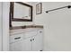 Bathroom vanity with a framed mirror, white cabinets, granite countertop, and decorative mosaic tile backsplash at 204 Dartmoor Ln, Raleigh, NC 27614