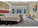 Spacious bedroom featuring neutral tones, plush carpet and an abundance of natural light from bay windows at 204 Dartmoor Ln, Raleigh, NC 27614