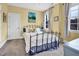 Cozy bedroom featuring a wrought iron bed frame, carpet, and bright, natural light from the window at 204 Dartmoor Ln, Raleigh, NC 27614